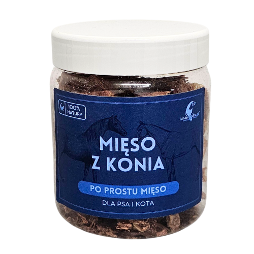 Przezroczysty słoik z białą nakrętką zawiera kawałki suszonego mięsa. Na etykiecie widnieje napis: \'MIĘSO Z KONIA PO PROSTU MIĘSO DLA PSA I KOTA\'.