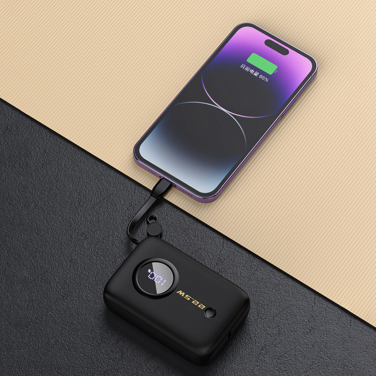 Na obrazie widać czarny powerbank z wyświetlaczem pokazującym \'100%\' oraz telefon z ekranem, na którym widoczny jest zielony symbol baterii i napis \'95%\'. Powerbank jest połączony z telefonem za pomocą kabla.