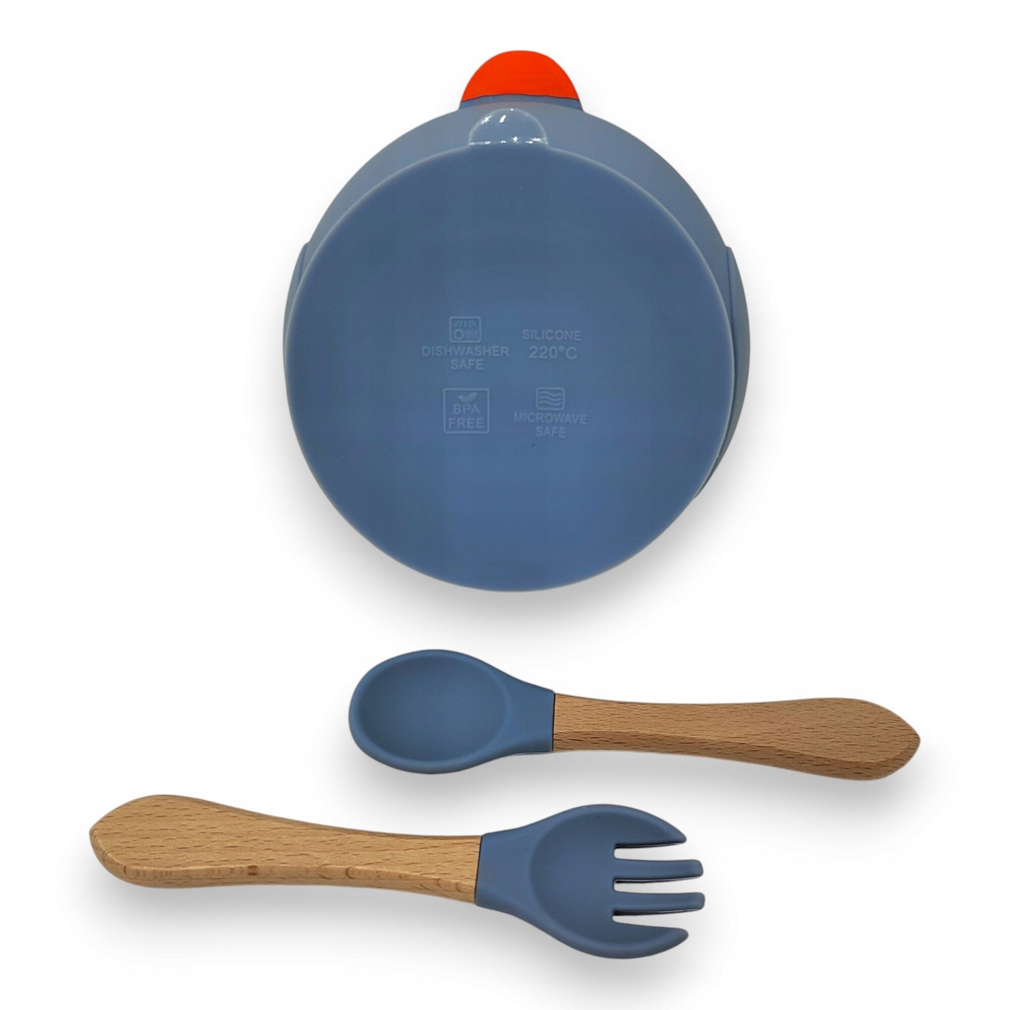Na obrazie widoczna jest niebieska miseczka z przyssawką oraz drewniane sztućce z niebieskimi końcówkami. Na miseczce znajdują się napisy: \'DISHWASHER SAFE\', \'SILICONE 220°C\', \'BPA FREE\', \'MICROWAVE SAFE\'.