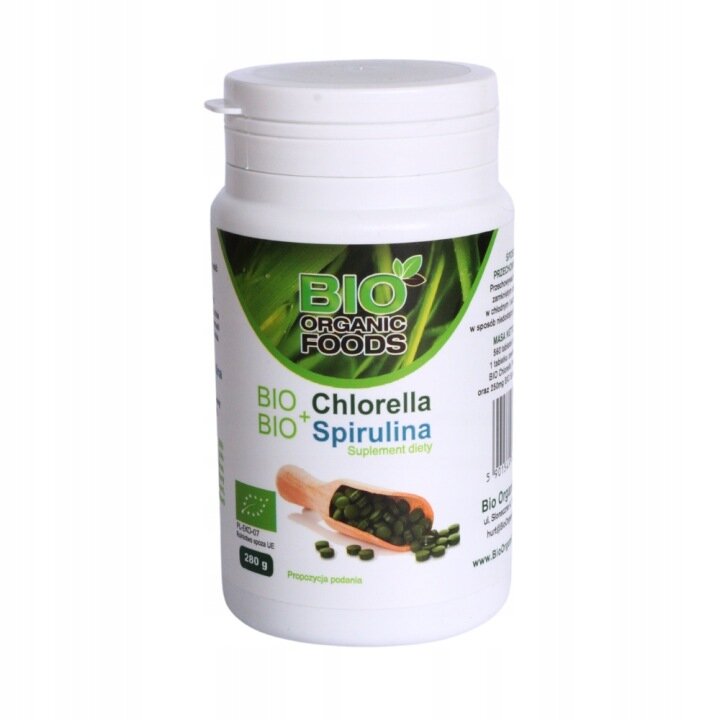 Biała plastikowa butelka z etykietą \'BIO ORGANIC FOODS\' oraz napisem \'BIO Chlorella BIO+ Spirulina Suplement diety\'. Na etykiecie widoczna jest ilustracja zielonych tabletek w drewnianej łyżce oraz logo certyfikatu ekologicznego UE.