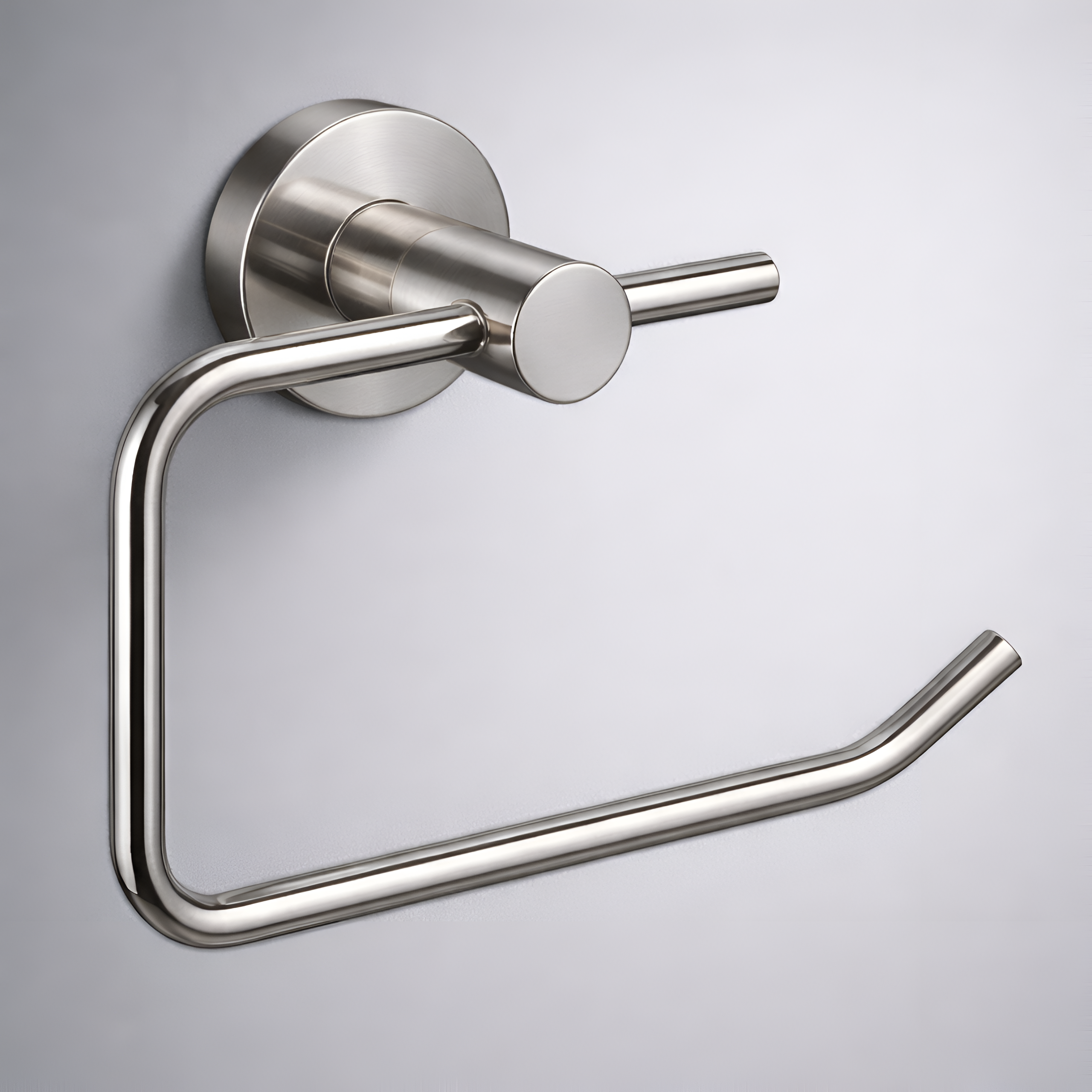 Metalowy uchwyt na papier toaletowy w kolorze srebrnym, zamontowany na ścianie. Uchwyt ma prosty, nowoczesny design z okrągłą podstawą mocującą.