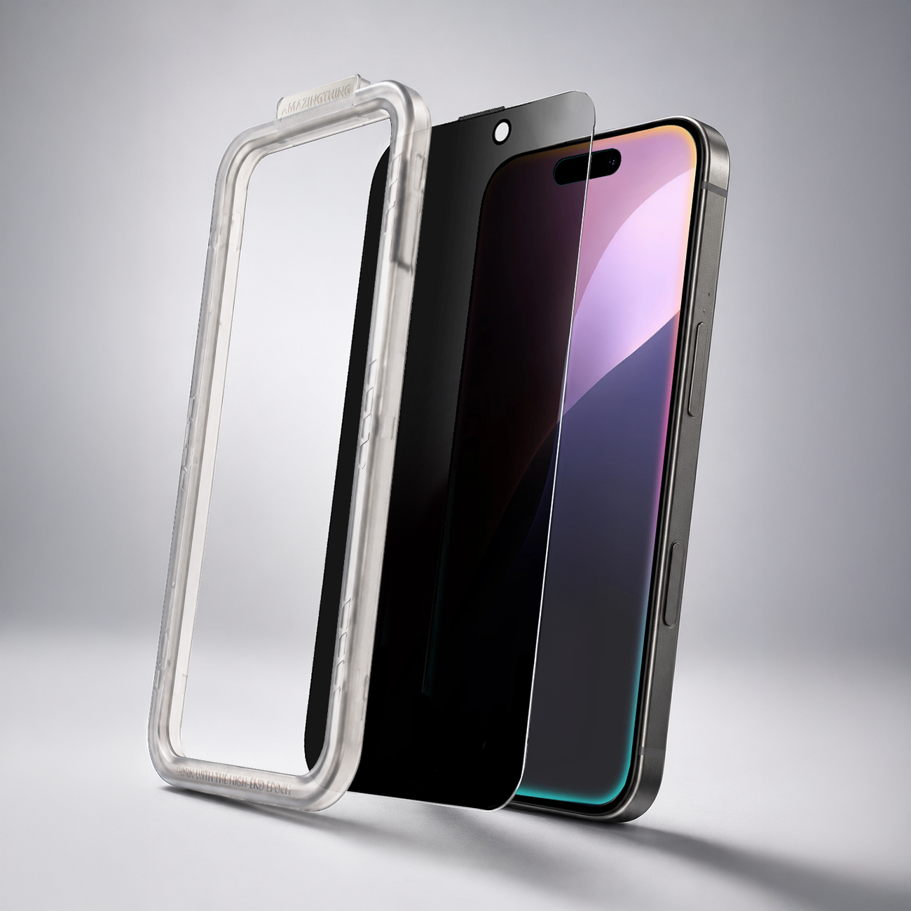 Obraz przedstawia trzy elementy: przezroczystą ramkę, ciemne szkło ochronne oraz smartfon z widocznym ekranem. Na ramce widoczny jest napis \'AMAZINGTHING\'.