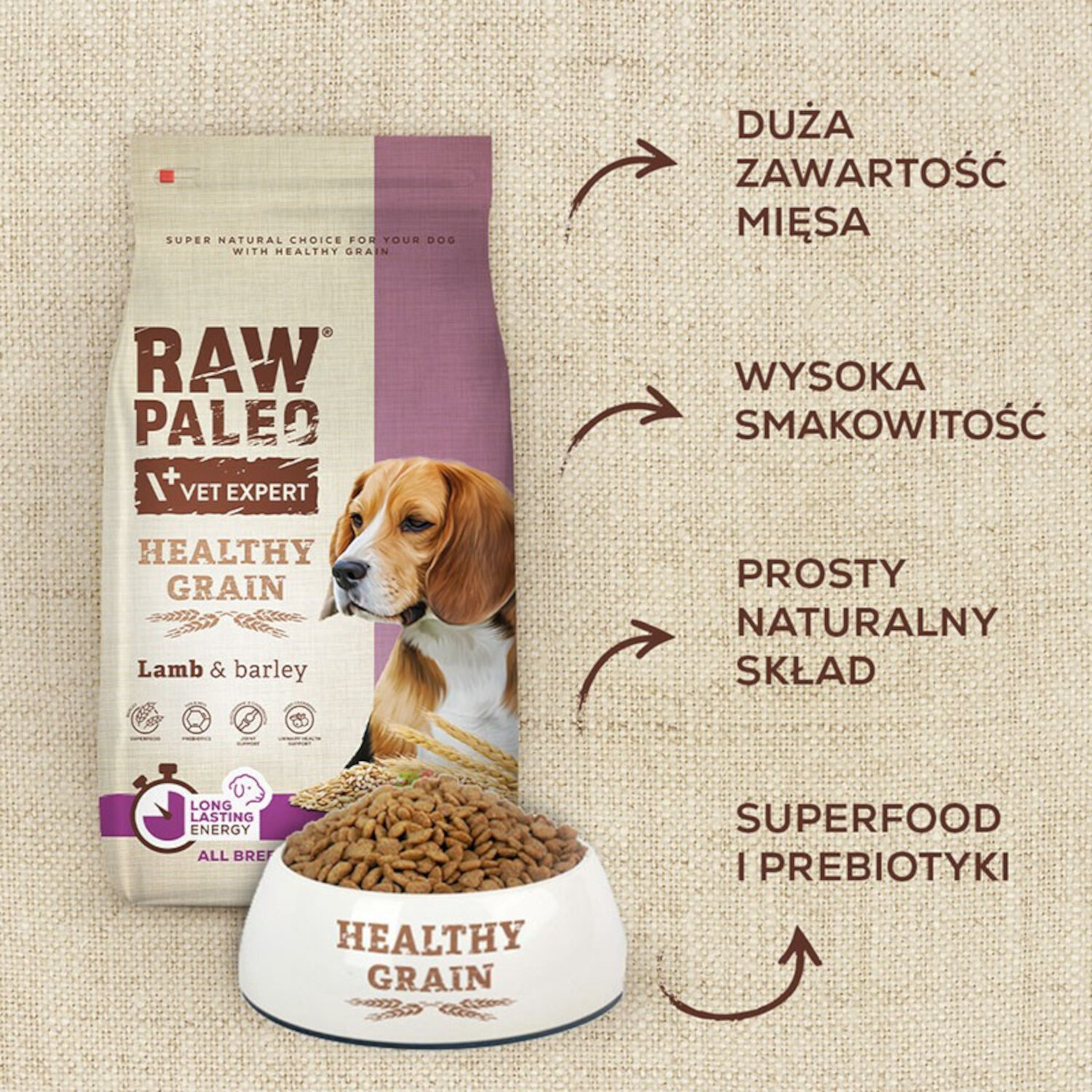 Na obrazie widoczna jest torba z karmą dla psów RAW PALEO VET EXPERT HEALTHY GRAIN z jagnięciną i jęczmieniem oraz miska z karmą. Obok znajdują się napisy: \'DUŻA ZAWARTOŚĆ MIĘSA\', \'WYSOKA SMAKOWITOŚĆ\', \'PROSTY NATURALNY SKŁAD\', \'SUPERFOOD I PREBIOTYKI\'.