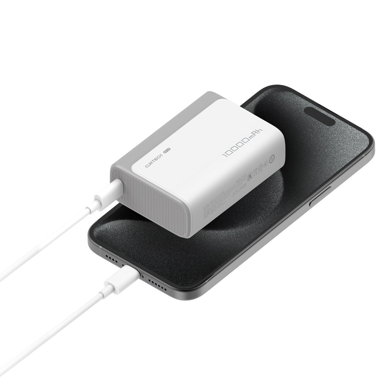 Na obrazie widać szary power bank z napisem \'Cuktech 30W 10000mAh\' podłączony do smartfona za pomocą białego kabla. Power bank leży na powierzchni telefonu.