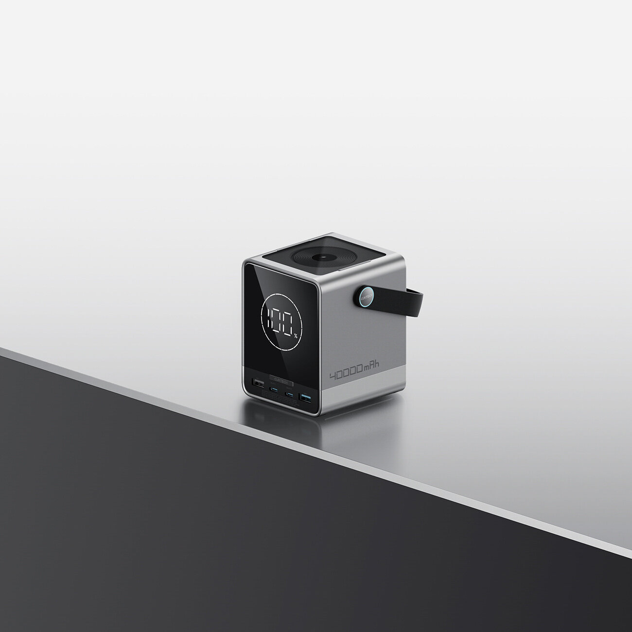 Na obrazie widoczny jest czarny powerbank o kształcie prostopadłościanu z wyświetlaczem pokazującym \'100%\'. Na boku urządzenia znajduje się napis \'40000mAh\' oraz porty USB-C i USB-A.