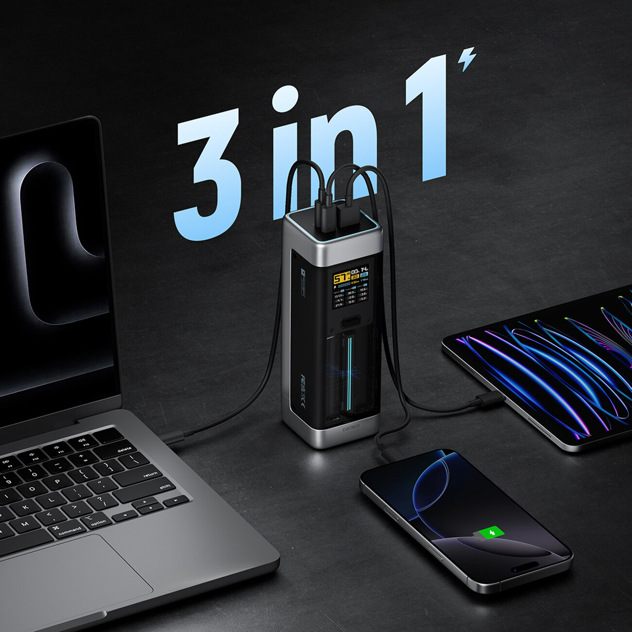 Na obrazie widoczny jest czarny powerbank z trzema podłączonymi urządzeniami: laptopem, tabletem i smartfonem. Na powerbanku wyświetlany jest tekst \'57%\' oraz napis \'3 in 1\' w tle.