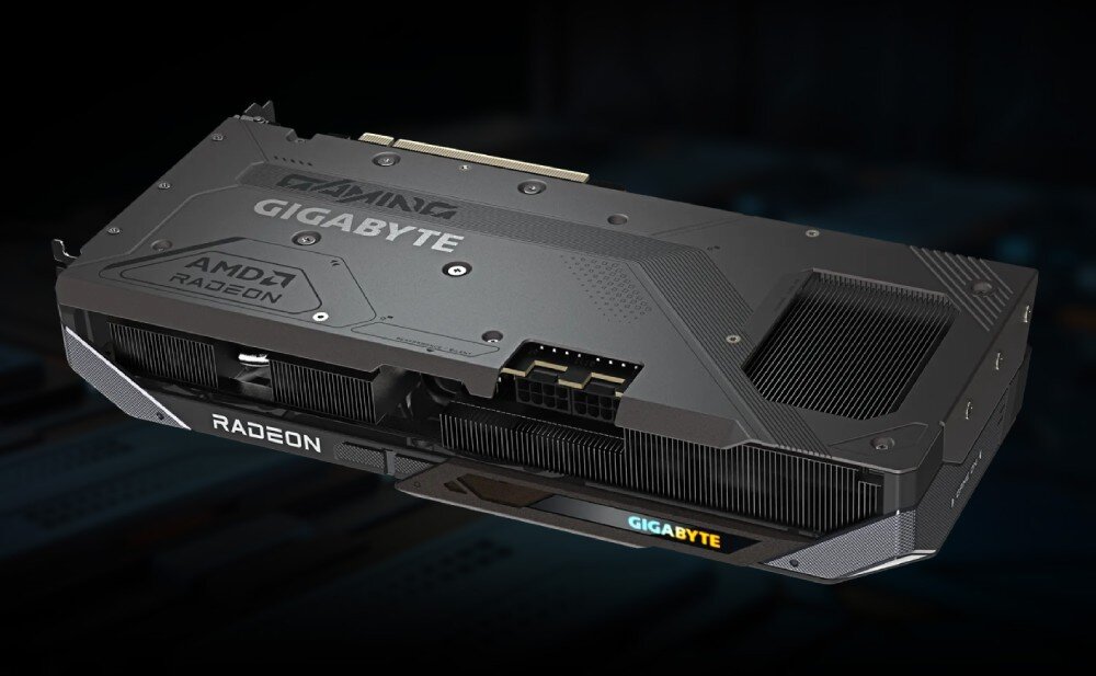 Na obrazie widoczna jest karta graficzna z napisami \'GIGABYTE\', \'AMD RADEON\' i \'RADEON\'. Karta ma ciemną obudowę z widocznymi elementami chłodzenia i złączem zasilania.