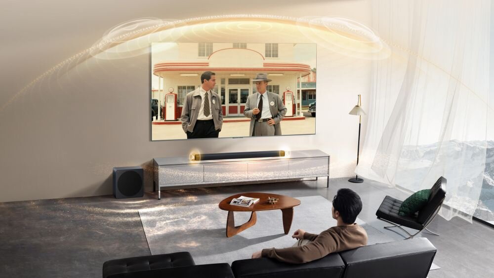 Soundbar TCL A65K Cube Chamber Bang & Olufsen TCL Golden Ear Dolby Atmos DTS:X, Soundbar i subwoofer w salonie z nakreślonymi świetlnymi falą dźwiękową idącymi z głośnika w stronę widza