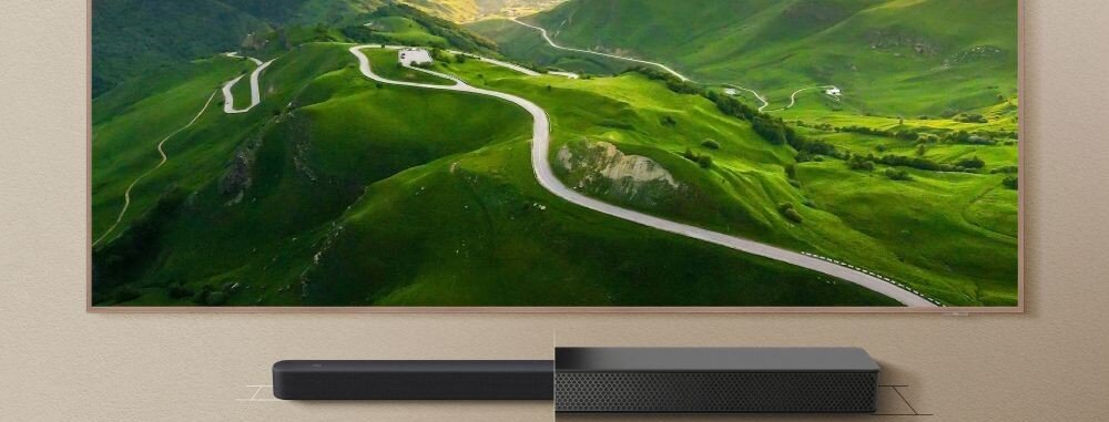 Soundbar TCL A65K obudowa 52 mm ciemnoszare wykończenie zaokrąglona konstrukcja, Porównanie wysokości soundbara 52 mm do tradycyjnego głośnika o wysokości większej niż 90 mm pod ekranem telewizora