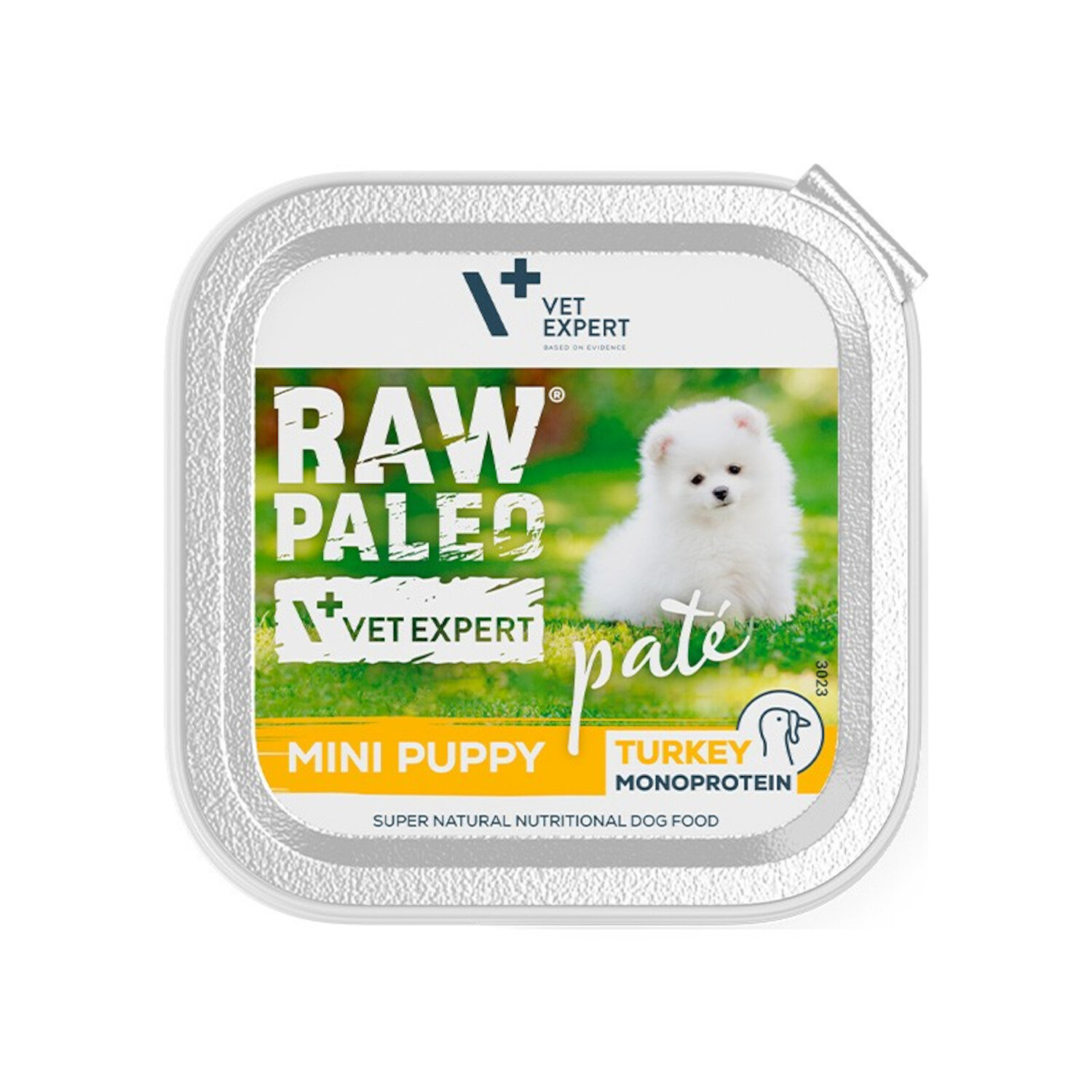 Opakowanie mokrej karmy dla szczeniąt z wizerunkiem białego psa na tle zieleni. Widoczny tekst: \'RAW PALEO\', \'VET EXPERT\', \'pate\', \'MINI PUPPY\', \'TURKEY MONOPROTEIN\', \'SUPER NATURAL NUTRITIONAL DOG FOOD\'.