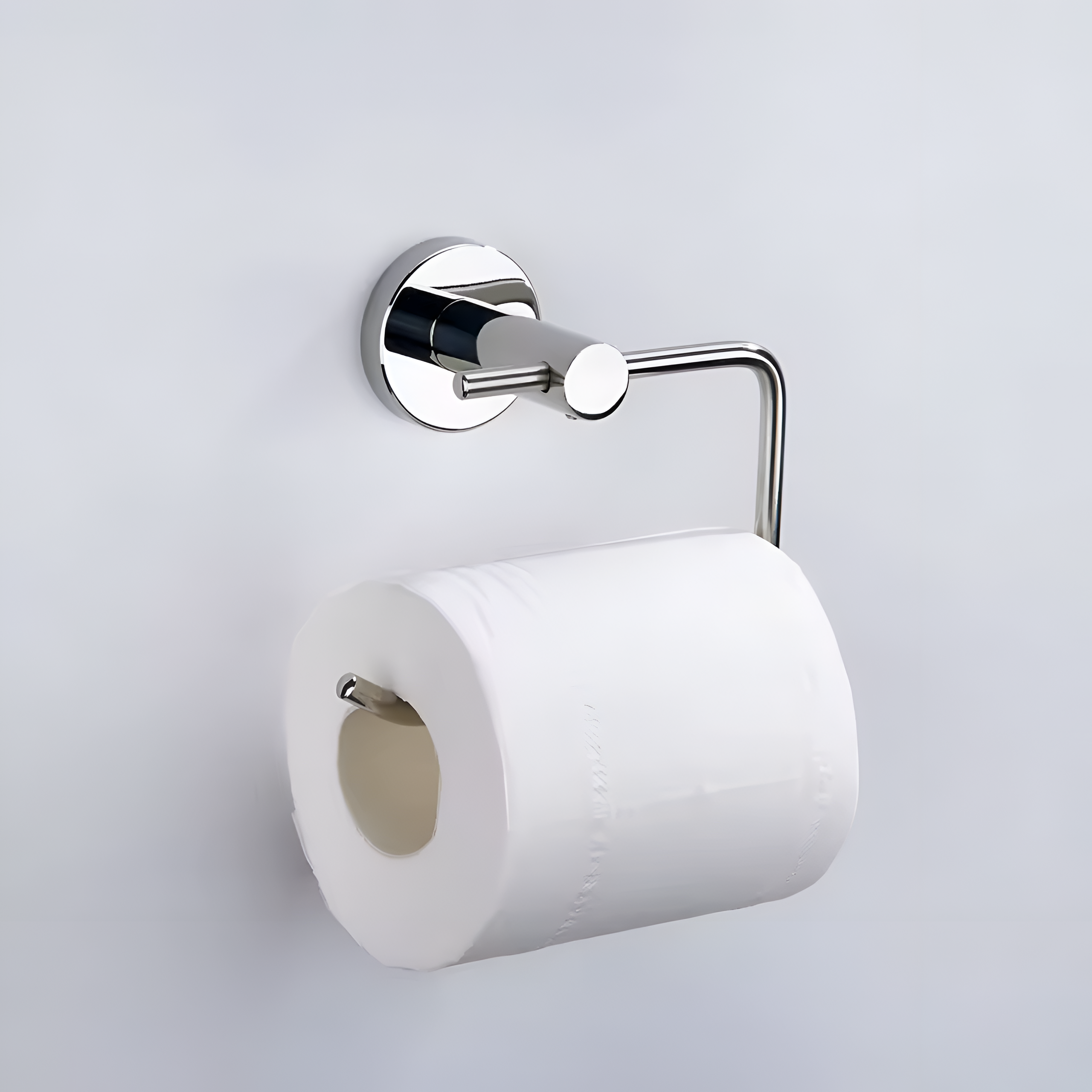 Metalowy uchwyt na papier toaletowy w kolorze chromu, zamontowany na ścianie, z rolką białego papieru toaletowego.