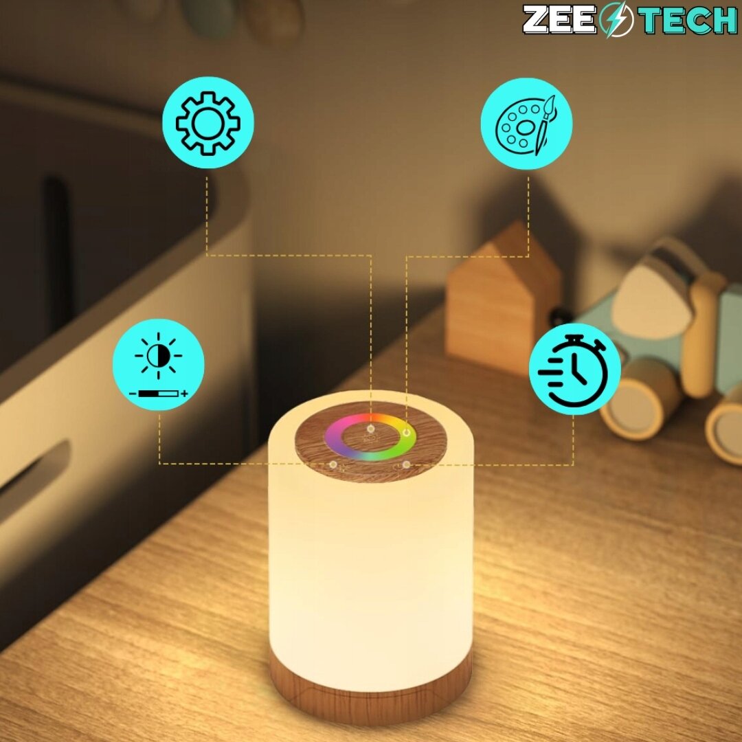 Na drewnianym stoliku znajduje się cylindryczna lampka nocna z drewnianą podstawą i dotykowym panelem na górze. Wokół lampki widoczne są ikony symbolizujące ustawienia, jasność, kolor i czasomierz, a w rogu znajduje się logo \'ZEE TECH\'.