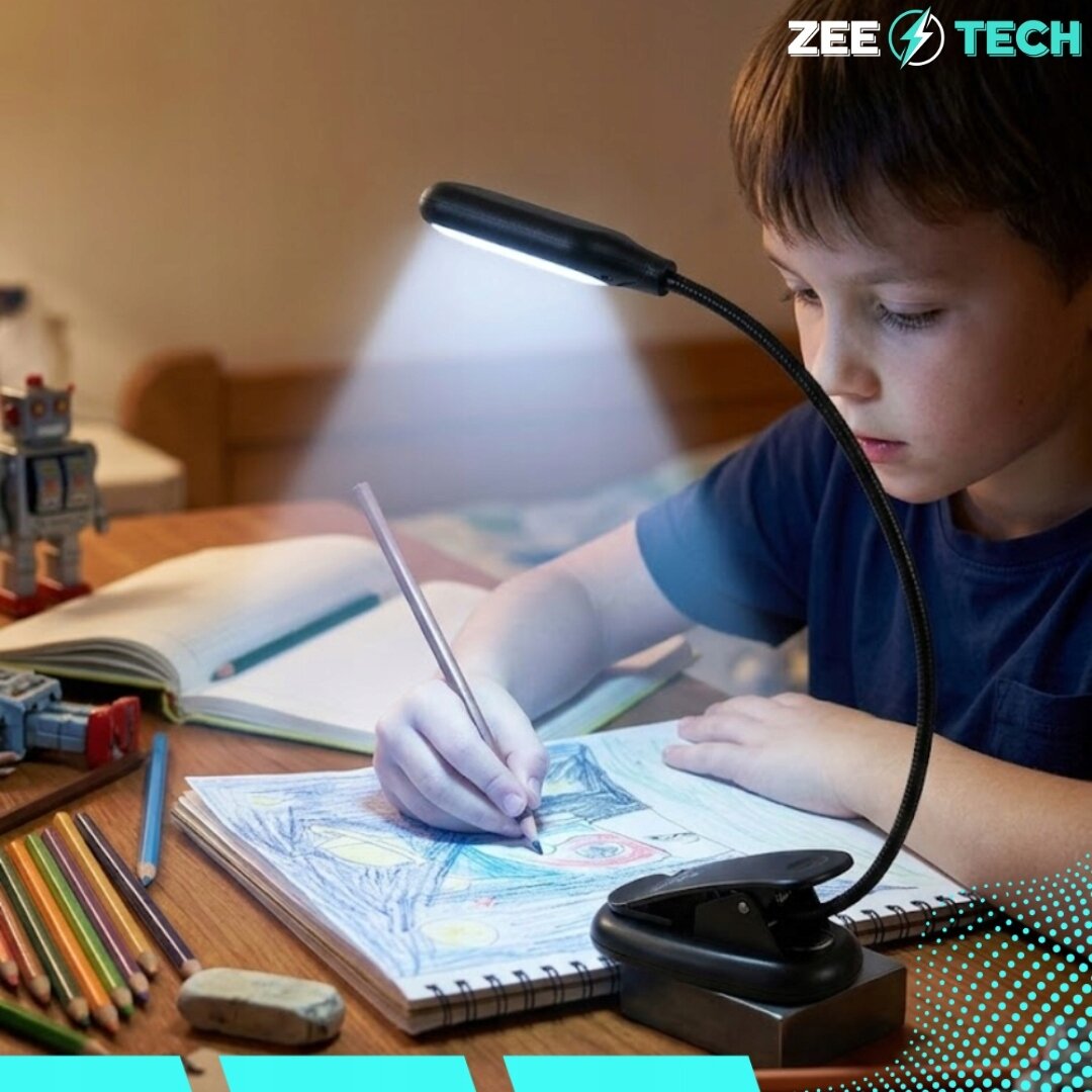 Dziecko rysuje przy biurku oświetlonym lampką z klipsem, emitującą białe światło. W tle widoczne są kredki, gumka do mazania i otwarty zeszyt, a w rogu logo \'ZEE TECH\'.