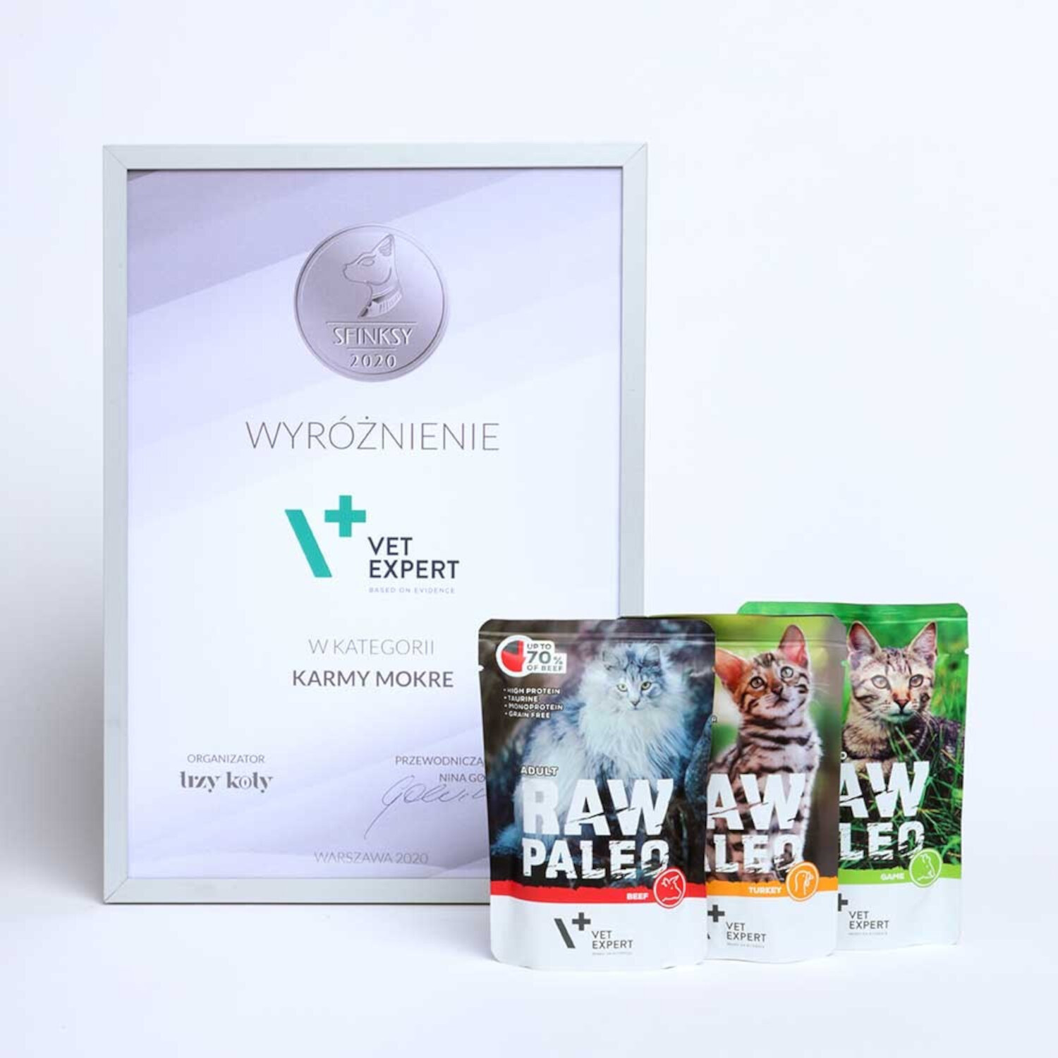 Na obrazie znajduje się wyróżnienie z napisem \'SFINKSY 2020 WYROŻNIENIE VET EXPERT W KATEGORII KARMY MOKRE\' oraz trzy opakowania karmy RAW PALEO z wizerunkami kotów i napisami \'BEEF\', \'TURKEY\', \'GAME\'.