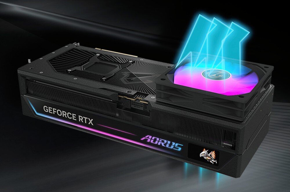 Obraz przedstawia kartę graficzną z widocznym napisem \'GEFORCE RTX\' oraz \'AORUS\'. Na karcie znajduje się podświetlony wentylator z efektem świetlnym.
