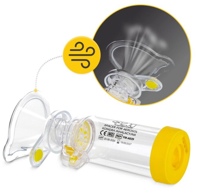 Przezroczysta komora do inhalacji z żółtymi elementami, z widocznym napisem: \'4FIZJO SPACER FOR AEROSOL KOMORA INHALACYJNA\'. Obok znajduje się symbol powietrza w żółtym kółku.