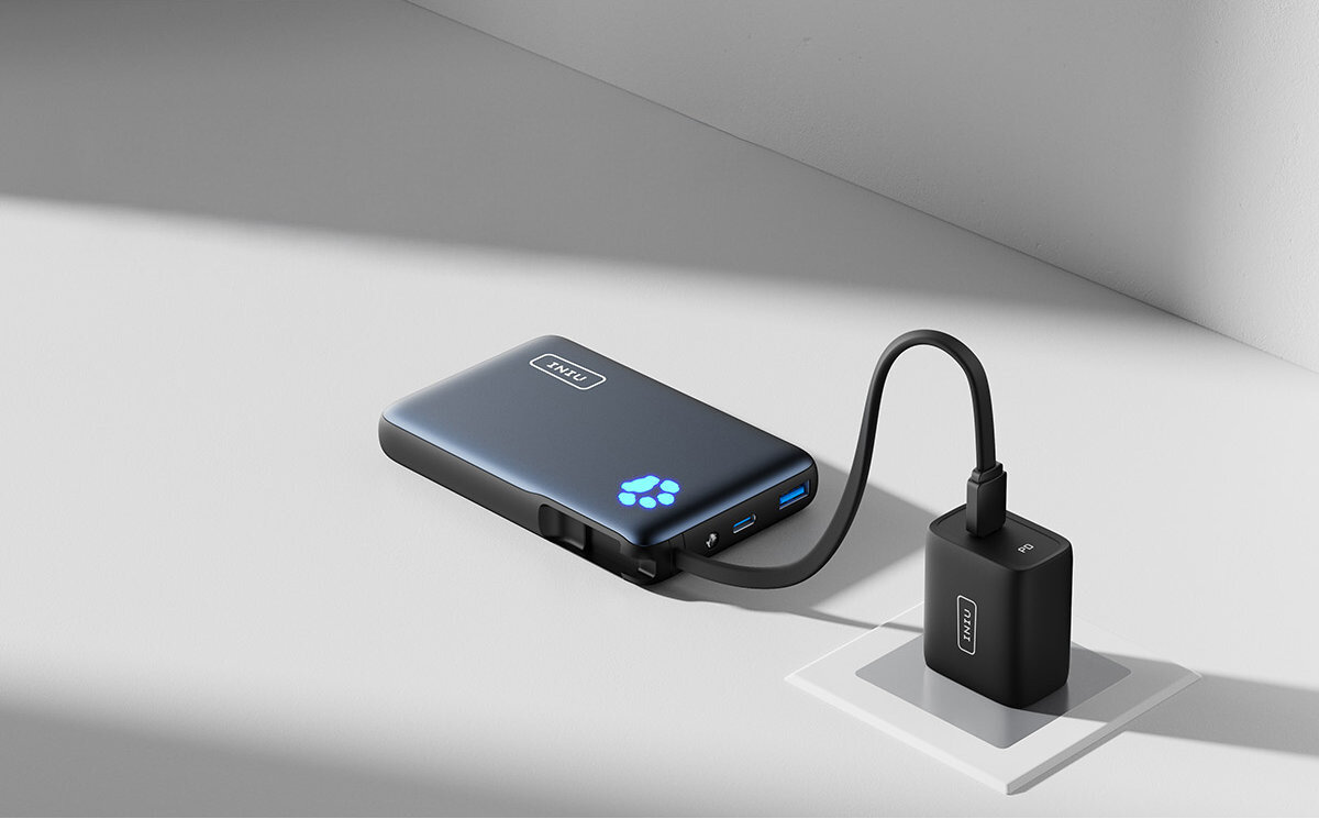 Na obrazie widoczny jest czarny powerbank z logo \'INIU\' oraz świecącym niebieskim symbolem łapy. Powerbank jest podłączony do czarnej ładowarki za pomocą kabla.
