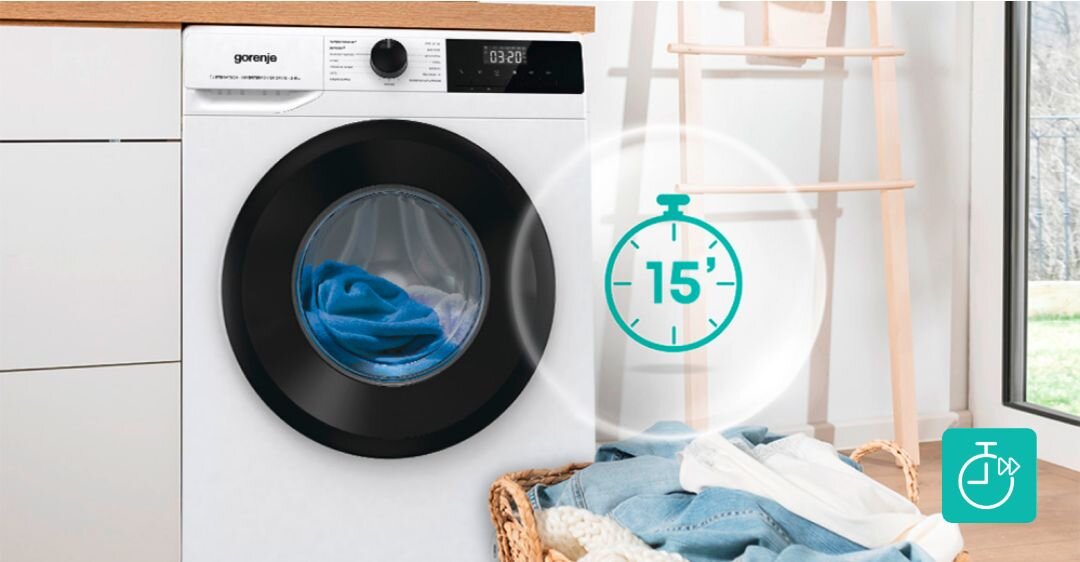 Pralka z widocznym logo \'gorenje\' na panelu sterowania, z wyświetlaczem pokazującym czas 03:20. Obok pralki znajduje się ikona zegara z liczbą \'15\', a na podłodze leży kosz z praniem.