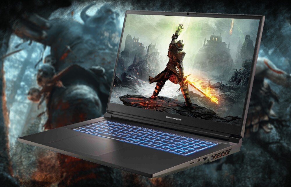 Laptop z podświetlaną klawiaturą wyświetla na ekranie grafikę przedstawiającą postać z płonącym mieczem na tle ruin. Na obudowie widoczne jest logo \'DREAM MACHINES\'.