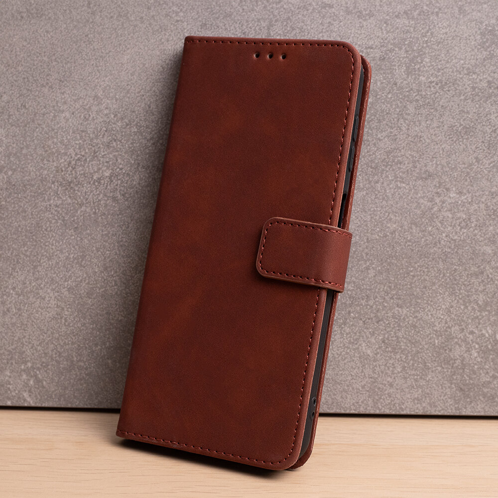 Brązowe etui na telefon z klapką, wykonane z materiału przypominającego skórę, z widocznym zapięciem na magnes.