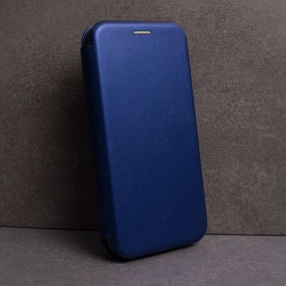 Granatowe etui na telefon z klapką, ustawione pionowo na tle szarej powierzchni. Na górze etui widoczny jest mały otwór na głośnik.