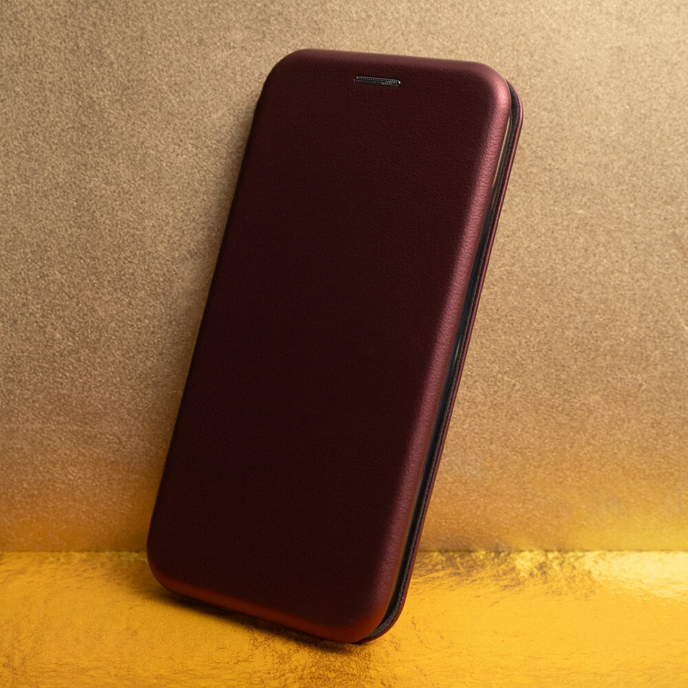 Burgundowe etui na telefon o gładkiej powierzchni, ustawione na tle w odcieniach złota i brązu.