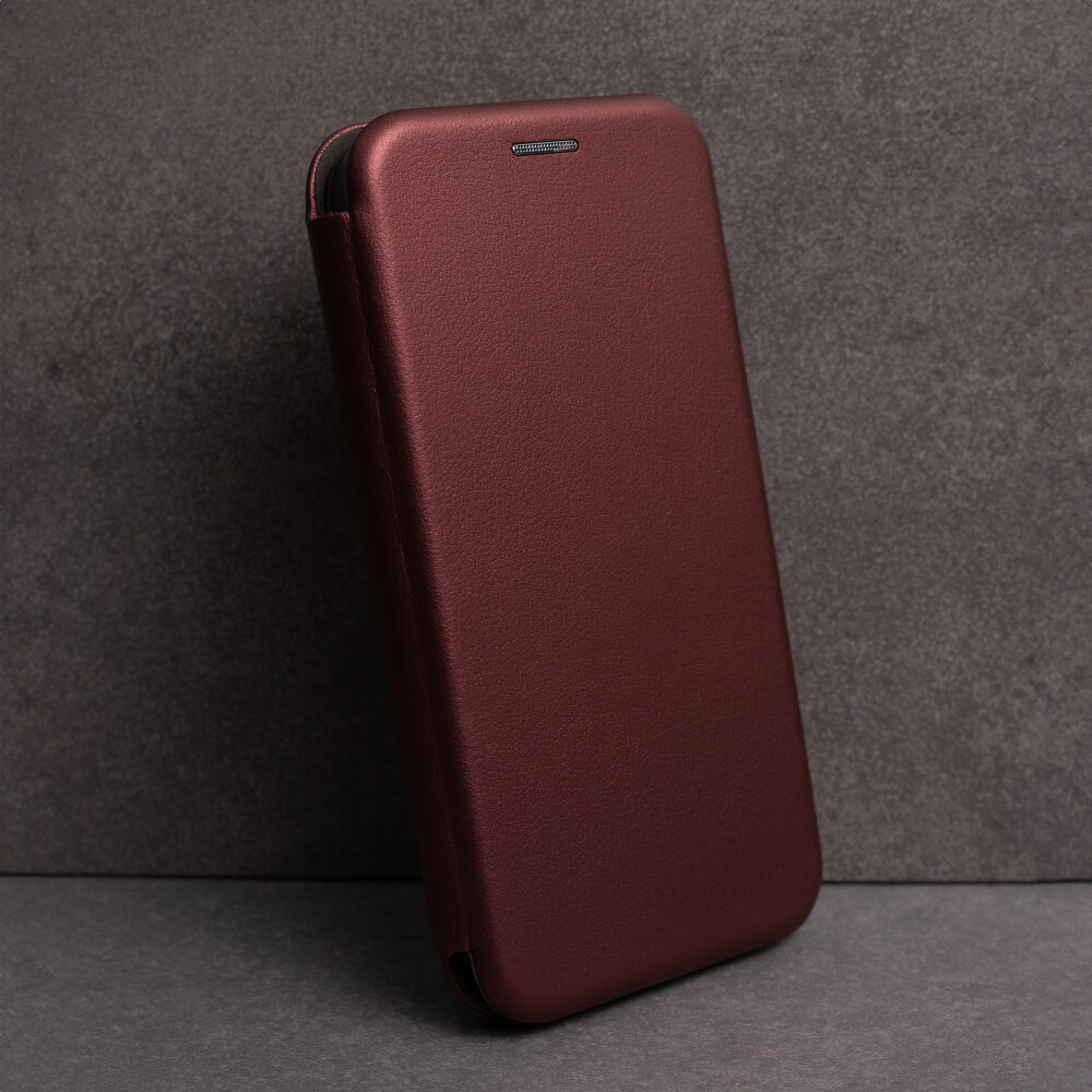 Burgundowe etui na telefon z klapką, wykonane z gładkiego materiału, ustawione pionowo na tle szarej powierzchni.