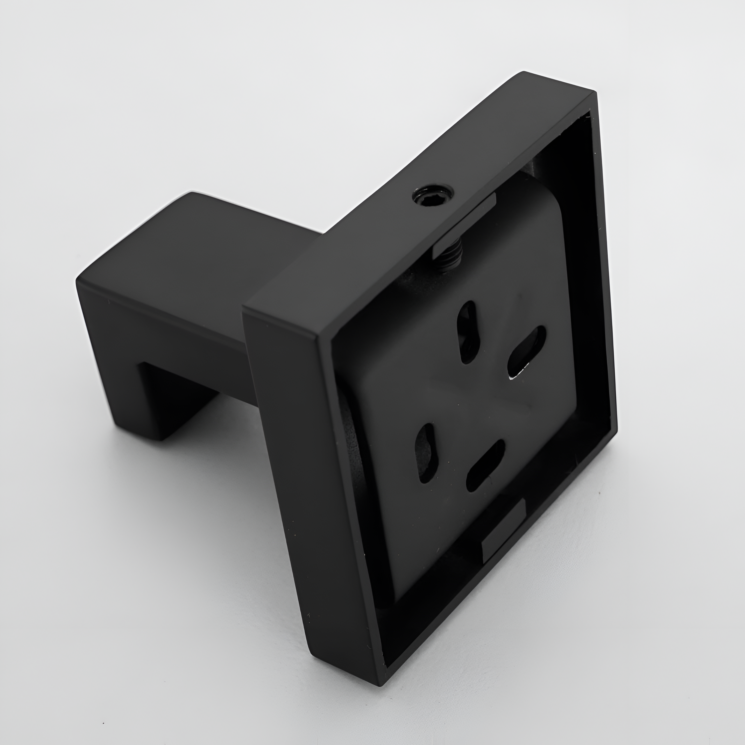 Czarny, kwadratowy wieszak na ręcznik z haczykiem ściennym, wykonany z metalu. Produkt ma prosty, nowoczesny design.