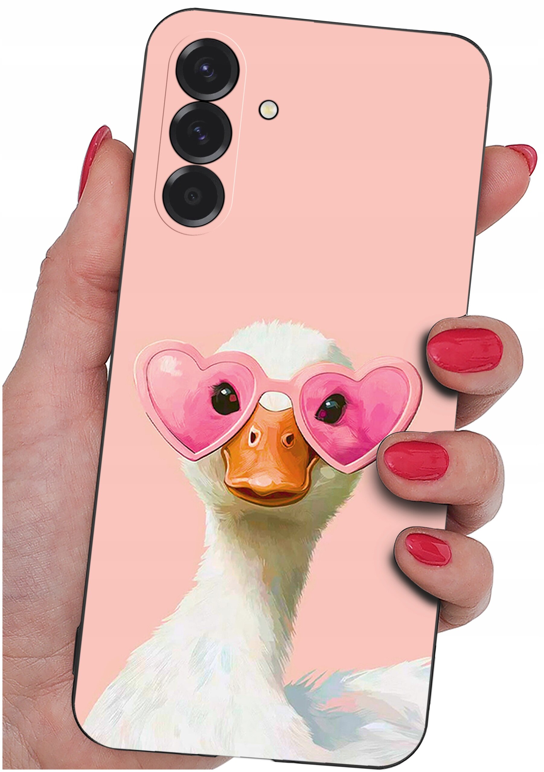 Etui na telefon z różowym tłem, przedstawiające kaczkę w różowych okularach w kształcie serc. Etui trzymane jest w dłoni z pomalowanymi na czerwono paznokciami.