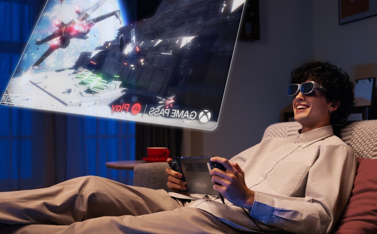 Osoba siedzi na kanapie, nosząc okulary i trzymając urządzenie do gier, podczas gdy przed nią wyświetlany jest obraz z gry. Na ekranie widoczne są loga \'GAME PASS\', \'EA Play\' oraz symbol Xbox.