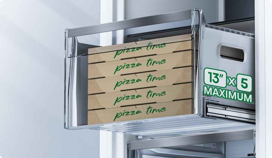 Wnętrze zamrażarki z widoczną szufladą, w której znajdują się pudełka z napisem \'pizza time\'. Obok szuflady widoczny jest napis \'13\