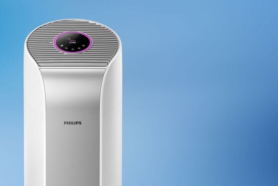 Na obrazie widoczny jest biały oczyszczacz powietrza z logo PHILIPS na przodzie. Na górze urządzenia znajduje się okrągły panel z wyświetlaczem i różowym podświetleniem.