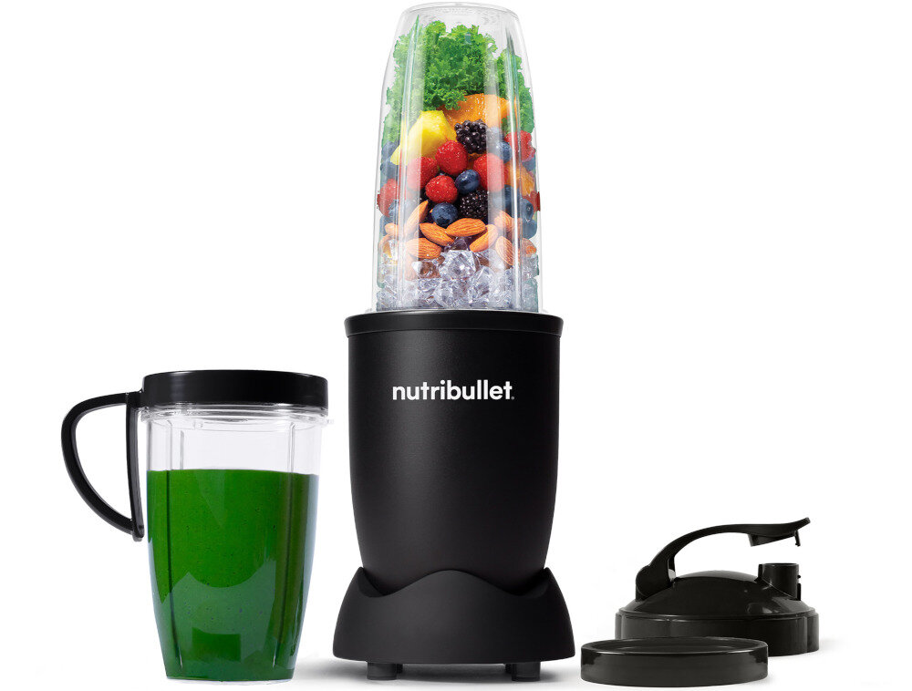 Na obrazie widoczny jest czarny blender z logo \'nutribullet\', wypełniony owocami i warzywami. Obok znajduje się kubek z zielonym napojem oraz dwa czarne wieczka.