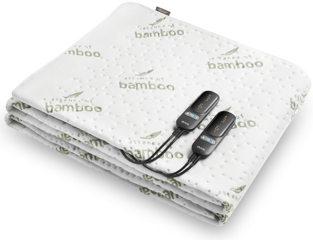 Na obrazie widoczny jest biały koc z nadrukiem \'essence of bamboo\' oraz dwoma czarnymi pilotami z wyświetlaczami i przyciskami. Logo \'DUUX\' znajduje się na pilotach.