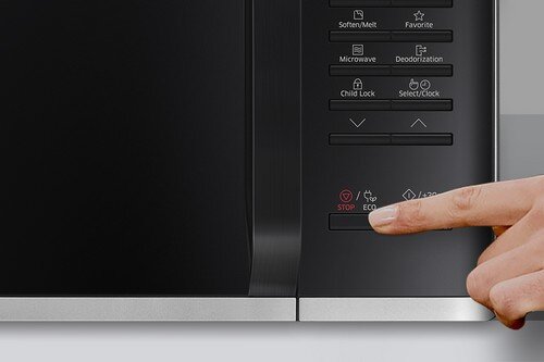 Zbliżenie na panel sterowania kuchenki mikrofalowej z przyciskami i ikonami, na którym widoczny jest palec naciskający przycisk \'STOP/ECO\'.