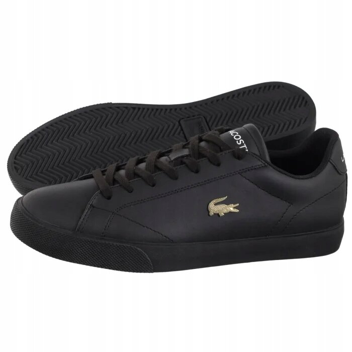 Czarne skórzane trampki z widocznym złotym logo krokodyla na boku. Na języku buta znajduje się napis \'LACOSTE\'.