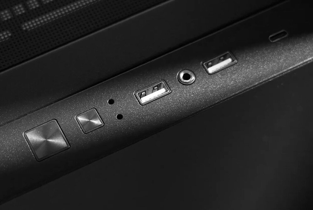 Czarny panel z przyciskami i portami, w tym dwa porty USB, gniazdo audio oraz dwa przyciski o metalicznym wykończeniu.