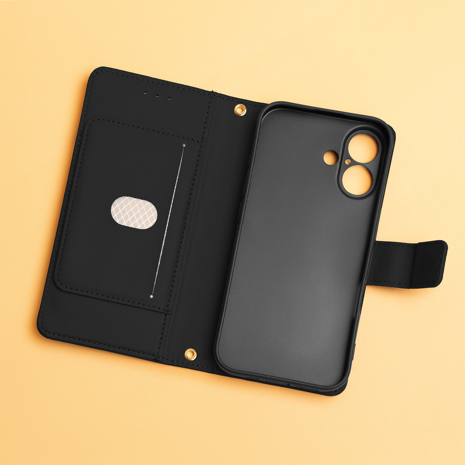 Czarne etui na telefon z miejscem na kartę i otworami na aparat, leży na żółtym tle. Etui ma zapięcie na zatrzask i wewnętrzną kieszeń z ozdobnym wzorem.