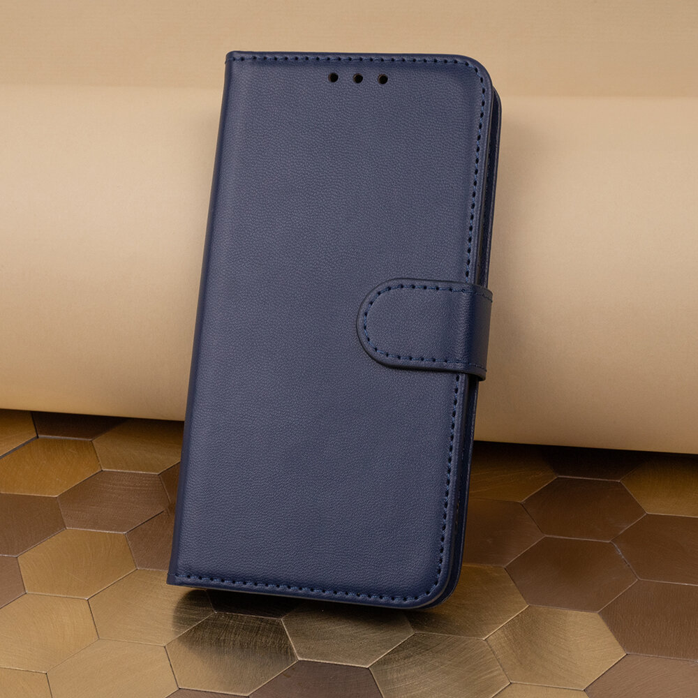 Granatowe etui na telefon z klapką, wykonane z materiału imitującego skórę, z widocznymi otworami na głośnik i zapięciem na magnes. Tło składa się z geometrycznych wzorów w odcieniach brązu i beżu.
