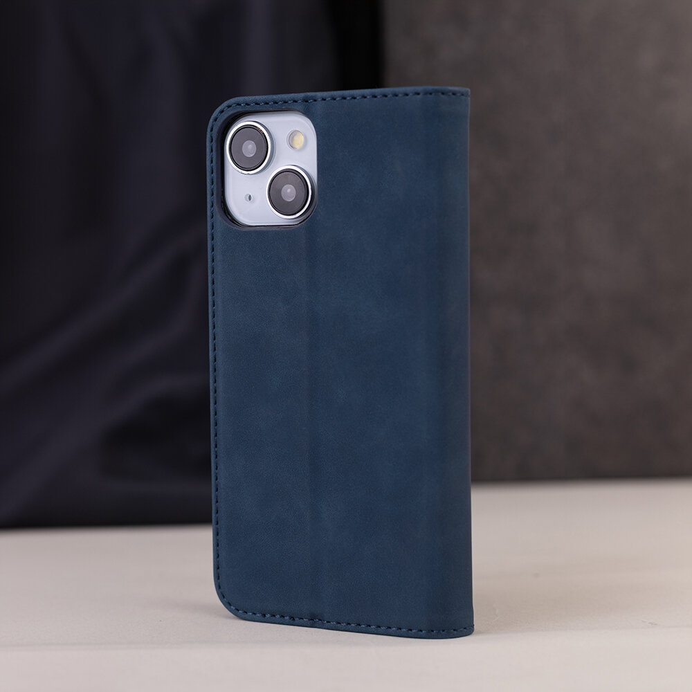 Granatowe etui na telefon z widocznymi dwoma obiektywami aparatu i lampą błyskową. Etui ma gładką powierzchnię i jest wykonane z materiału przypominającego zamsz.