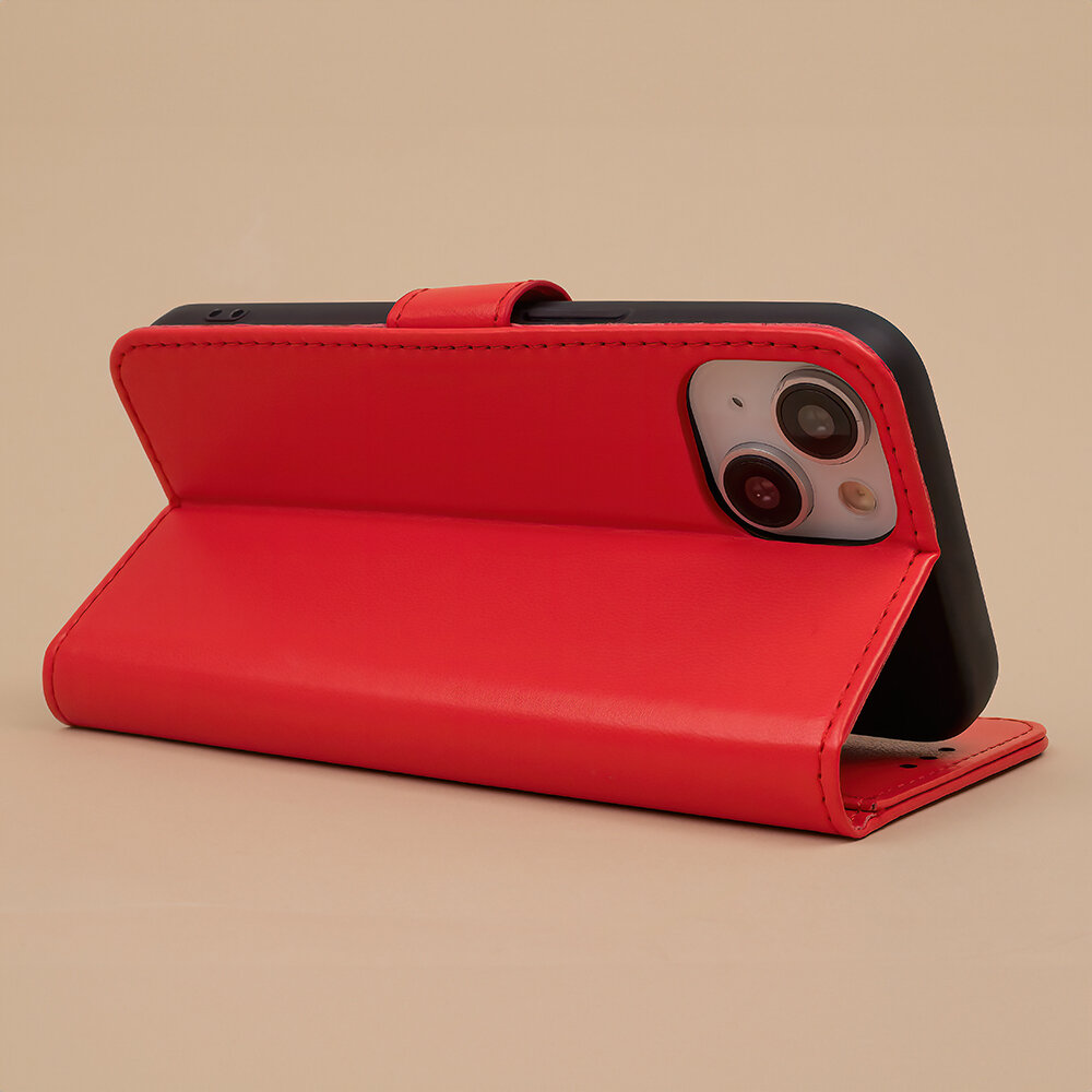 Czerwone etui na telefon w pozycji stojącej, z widocznymi wycięciami na aparat. Etui wykonane jest z materiału przypominającego skórę.