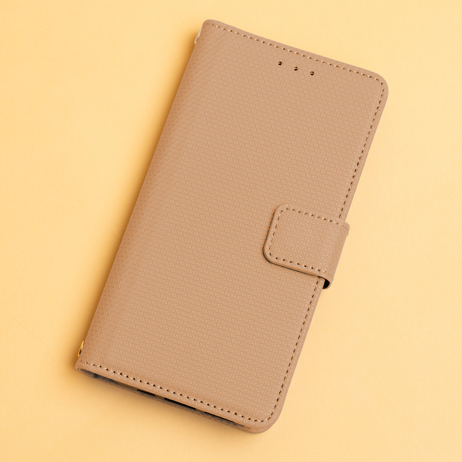 Brązowe etui na telefon z fakturą w drobne trójkąty, posiada zapięcie na magnes.