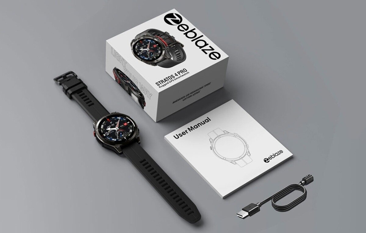 Na obrazie znajduje się smartwatch z czarnym paskiem, pudełko z napisem \'Zeblaze Stratos 4 Pro\', instrukcja obsługi oraz kabel USB. Logo \'zeblaze\' widoczne jest na pudełku i instrukcji.