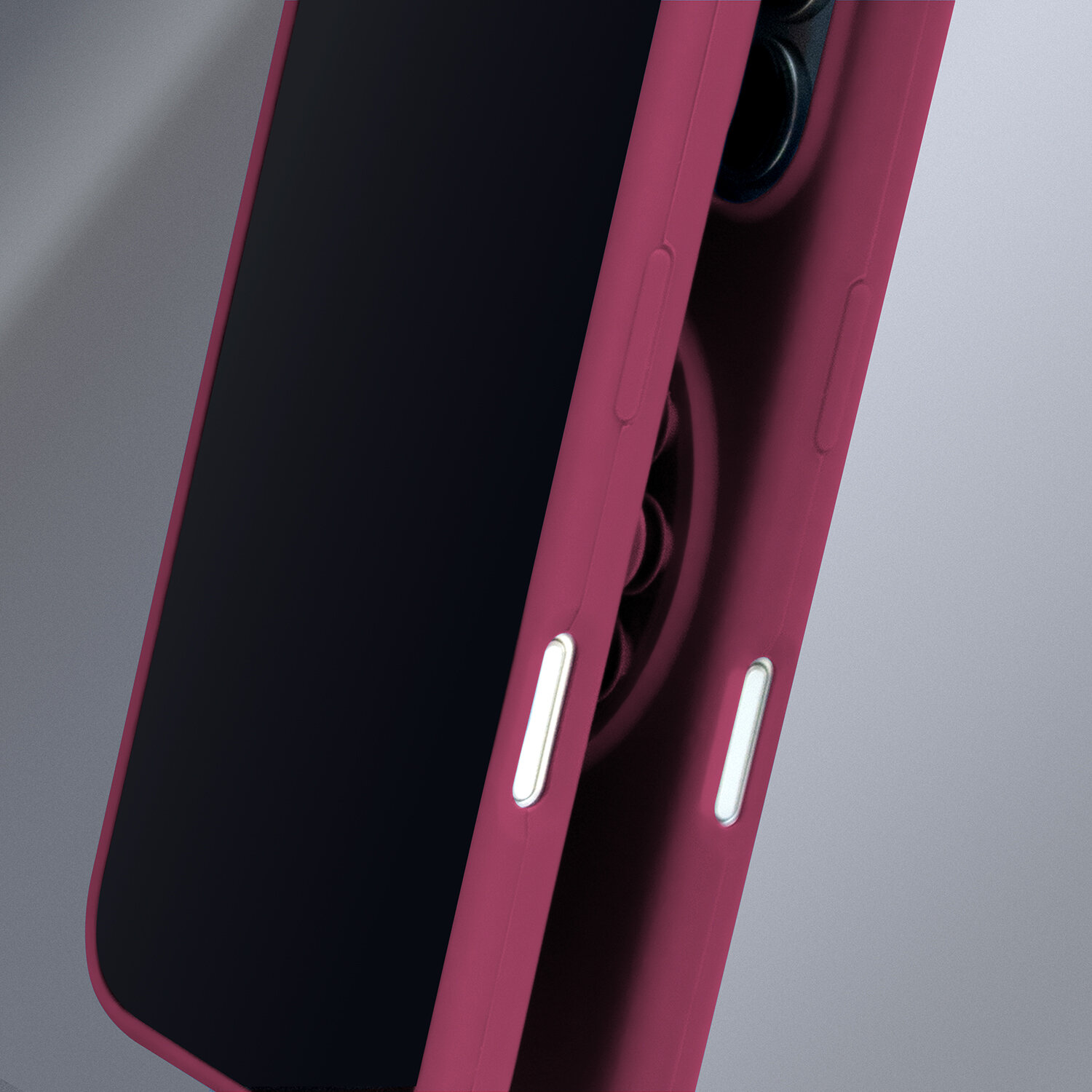 Bordowa nakładka silikonowa na smartfon z widocznymi przyciskami bocznymi i otworami na aparat. Tło jest szare.