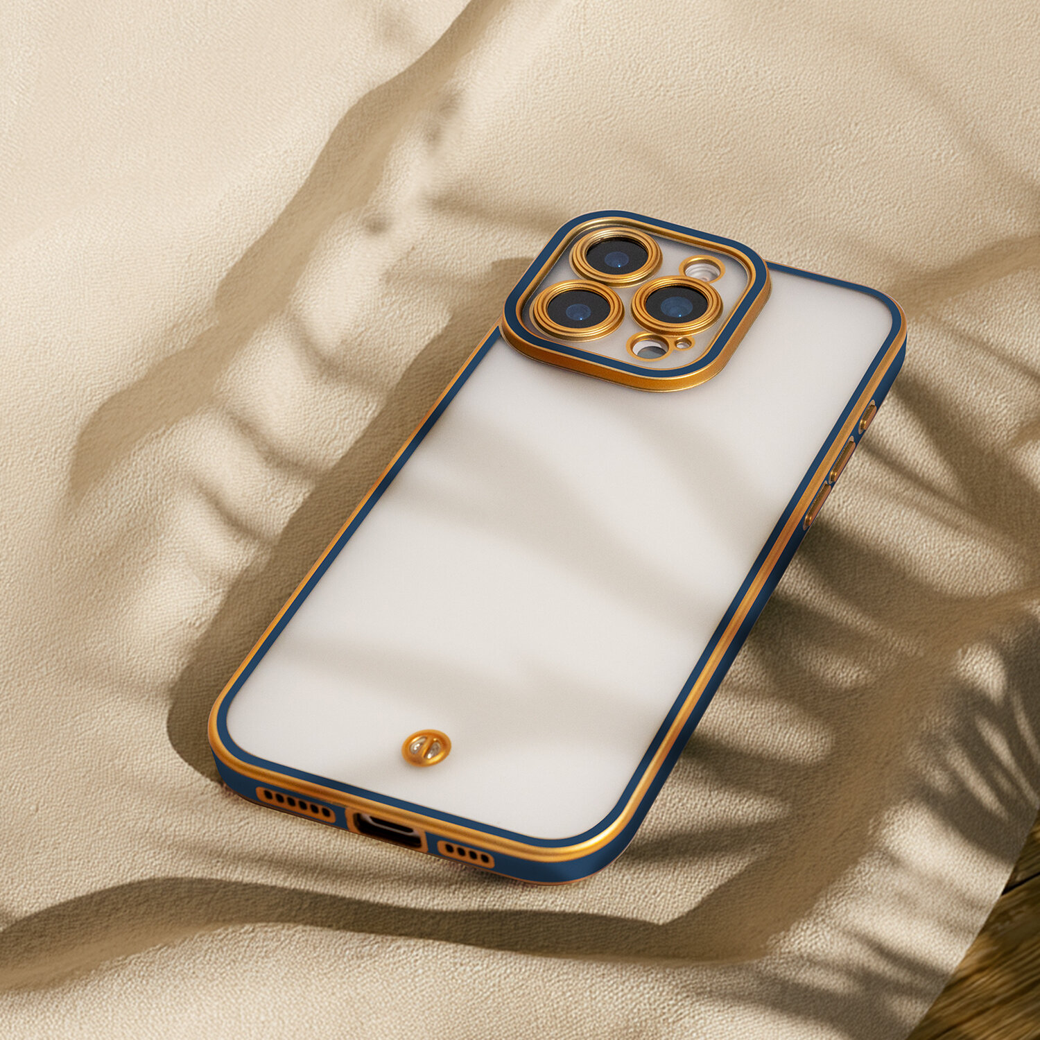 Na obrazie widoczny jest telefon w etui o złotych i niebieskich krawędziach, leżący na jasnym tle. Etui ma wycięcia na aparat i porty, a na tylnej części znajduje się małe logo.
