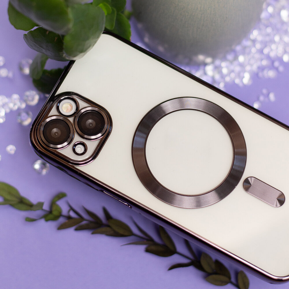 Na obrazie widoczny jest telefon z białą nakładką, posiadającą metaliczny pierścień wokół aparatu. W tle znajdują się zielone liście i dekoracyjne kamienie na fioletowym tle.