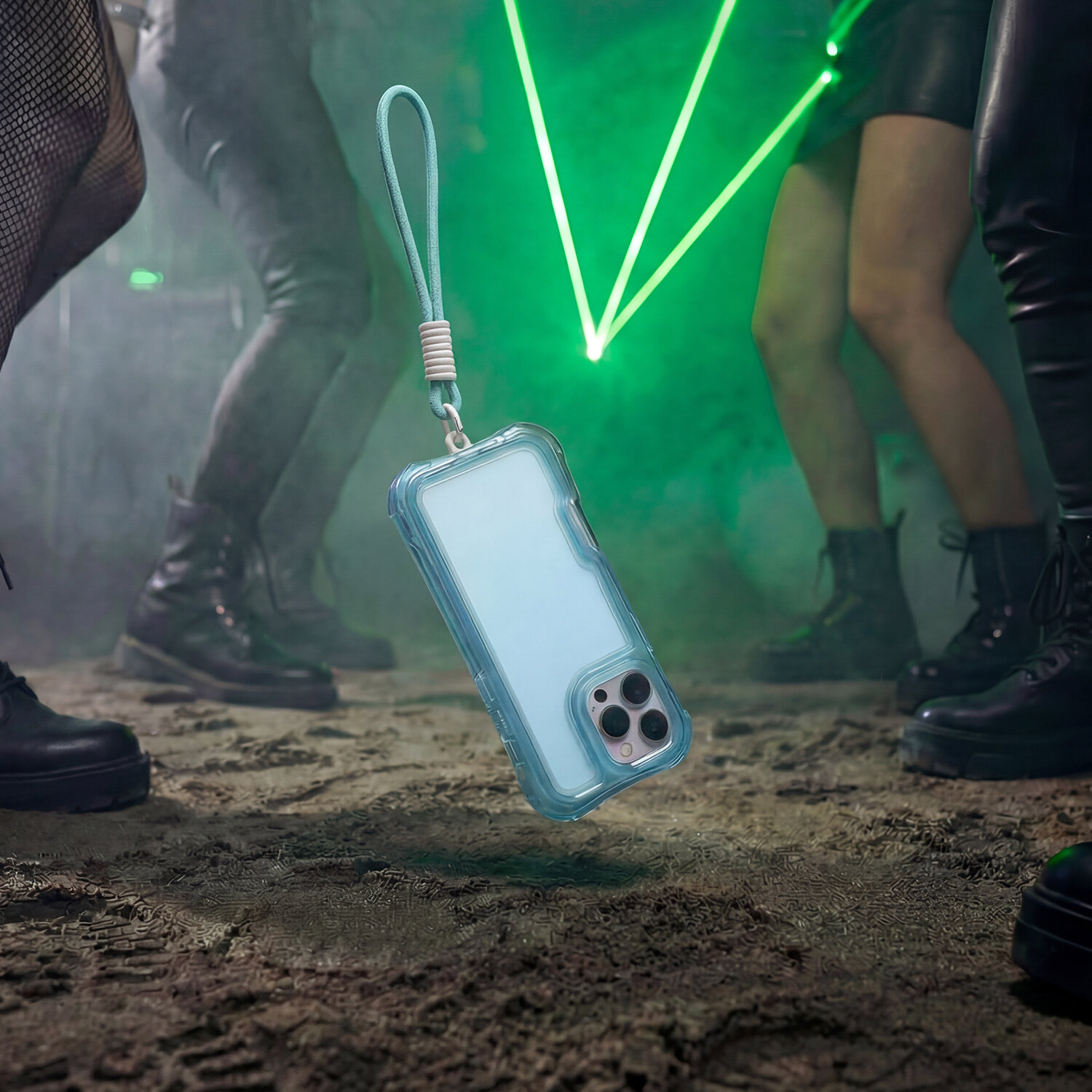 Niebieska nakładka na telefon z przezroczystym etui i smyczą unosi się nad ziemią w otoczeniu osób w ciemnym pomieszczeniu z zielonymi laserami.