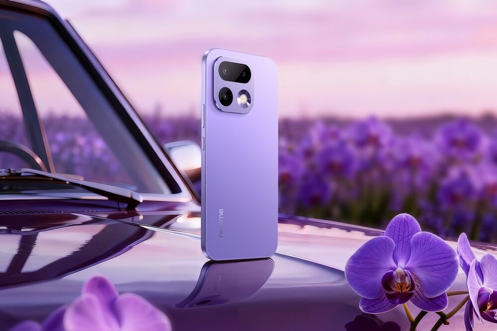 Fioletowy smartfon stoi na masce samochodu, w tle widoczne są kwiaty i rozmyte pole lawendy. Na obudowie telefonu widnieje napis \'realme\'.
