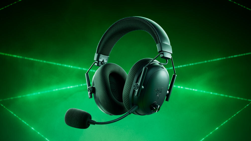 Czarne słuchawki nauszne z mikrofonem na tle zielonego, świetlnego wzoru. Widoczne logo producenta: RAZER.