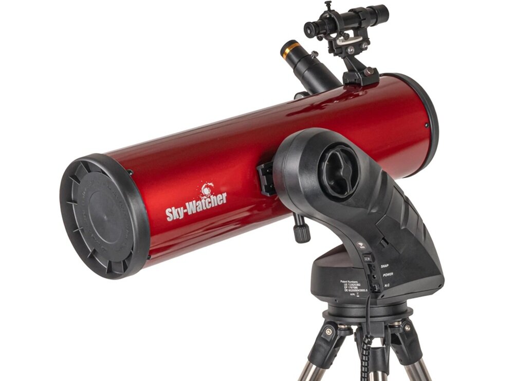 Czerwony teleskop z napisem \'Sky-Watcher\' na tubie, zamontowany na czarnym statywie z mechanizmem sterującym. Widoczny jest również celownik optyczny na górze tuby.